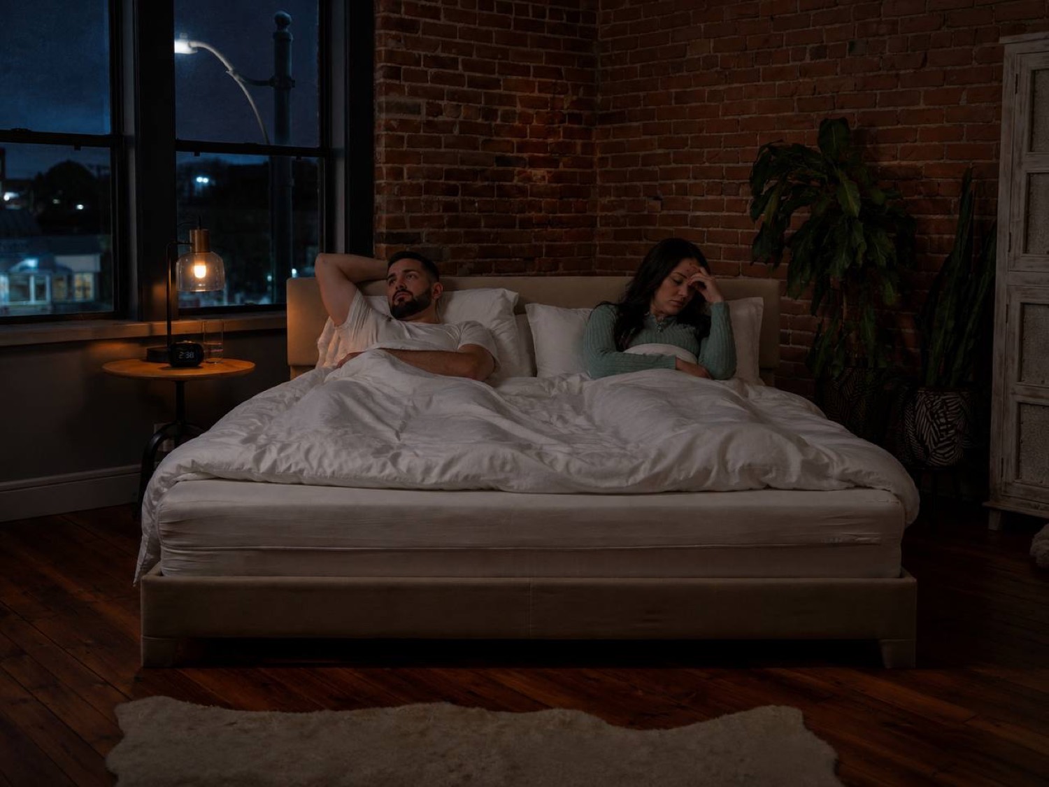 Couple lying awake at night, unable to sleep